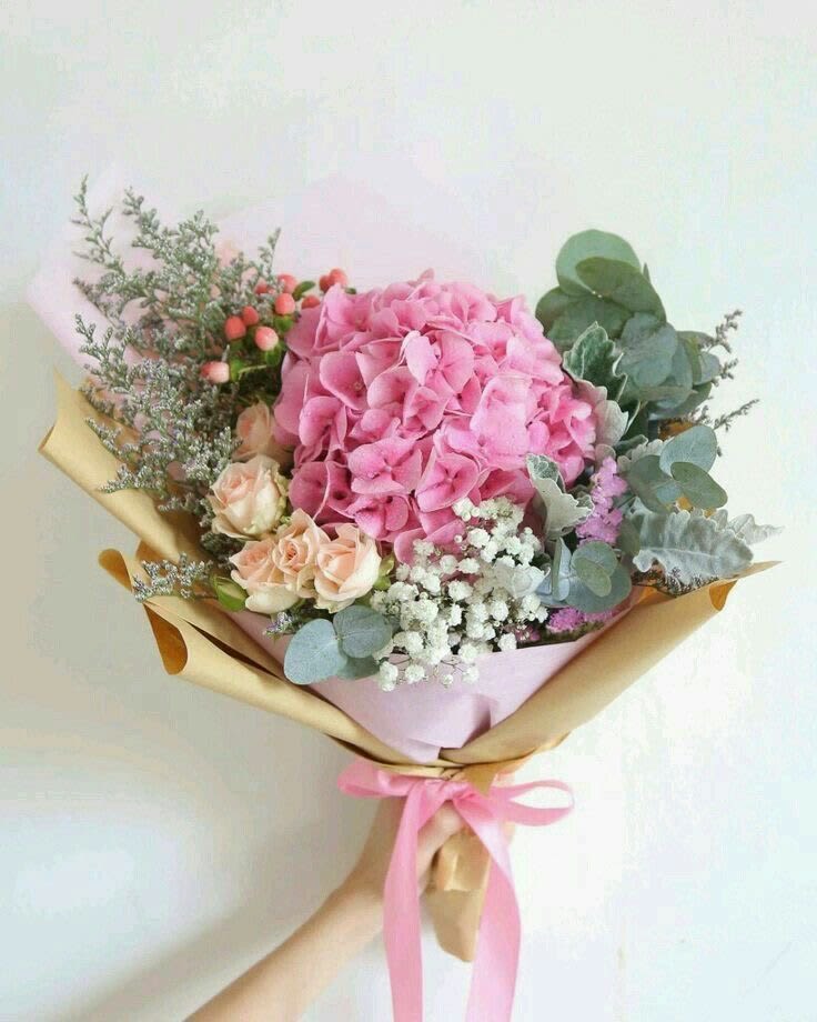 Bouquet of pink hydrangea and peach roses wrapped in paper