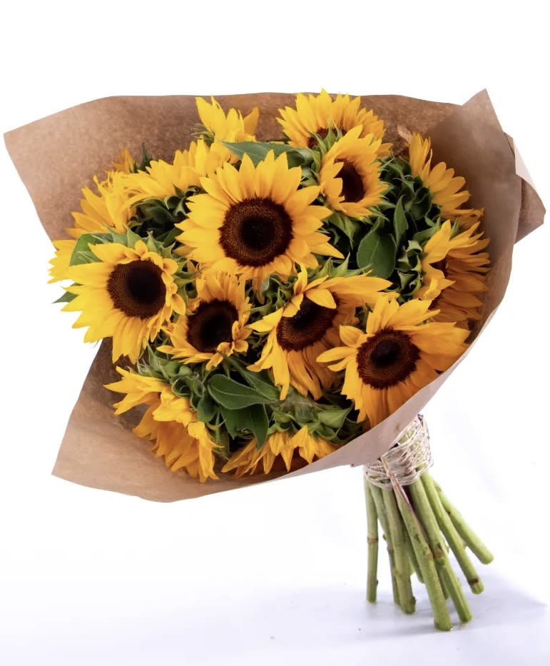 Bouquet of yellow sunflowers wrapped in brown paper