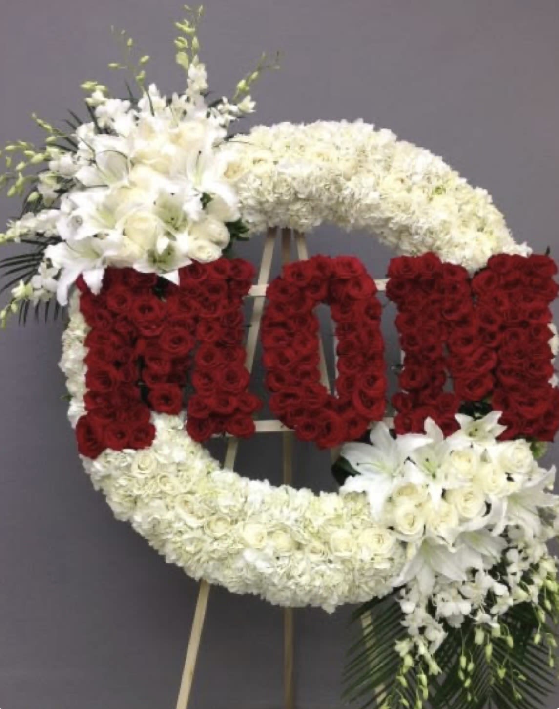 Flowers MOM - Express your deepest sympathy and honor the loving memory of a mother with our elegant Red &amp; White Rose and Lily Arrangement. Thoughtfully designed with pure white lilies symbolizing peace and the soul’s serenity, and rich red roses representing deep love and respect, this bouquet conveys emotions words cannot fully express.  This graceful arrangement is created to bring comfort during a time of loss and to pay tribute to a life filled with care, warmth, and unconditional love. Each flower is carefully selected to reflect dignity, compassion, and remembrance.  Perfect for funeral services, memorials, or sending condolences to loved ones, this bouquet offers a heartfelt way to stand beside those who grieve and celebrate the beautiful legacy of a beloved mother.