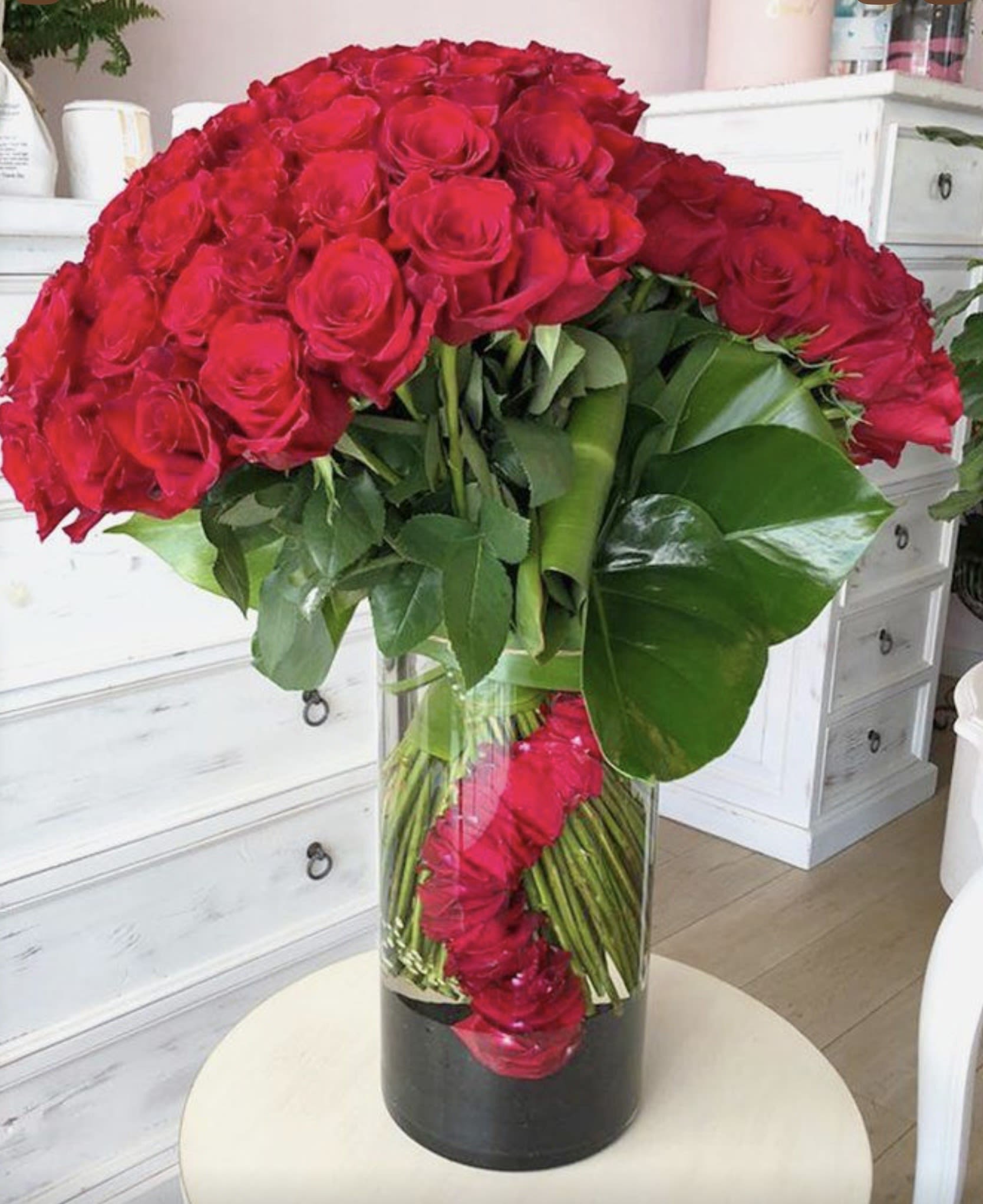 Two Level Red Roses Vase _ Same Day Delivery  - Make a bold and unforgettable statement with our Crimson Cascade Luxury Vase. This breathtaking arrangement features premium long-stem red roses artistically designed in a dramatic cascading style inside a modern glass vase. Rich red blooms symbolize deep love, passion, and admiration, while tropical foliage adds elegance and sophistication. Perfect for anniversaries, romantic celebrations, birthdays, or any occasion when only something extraordinary will do.