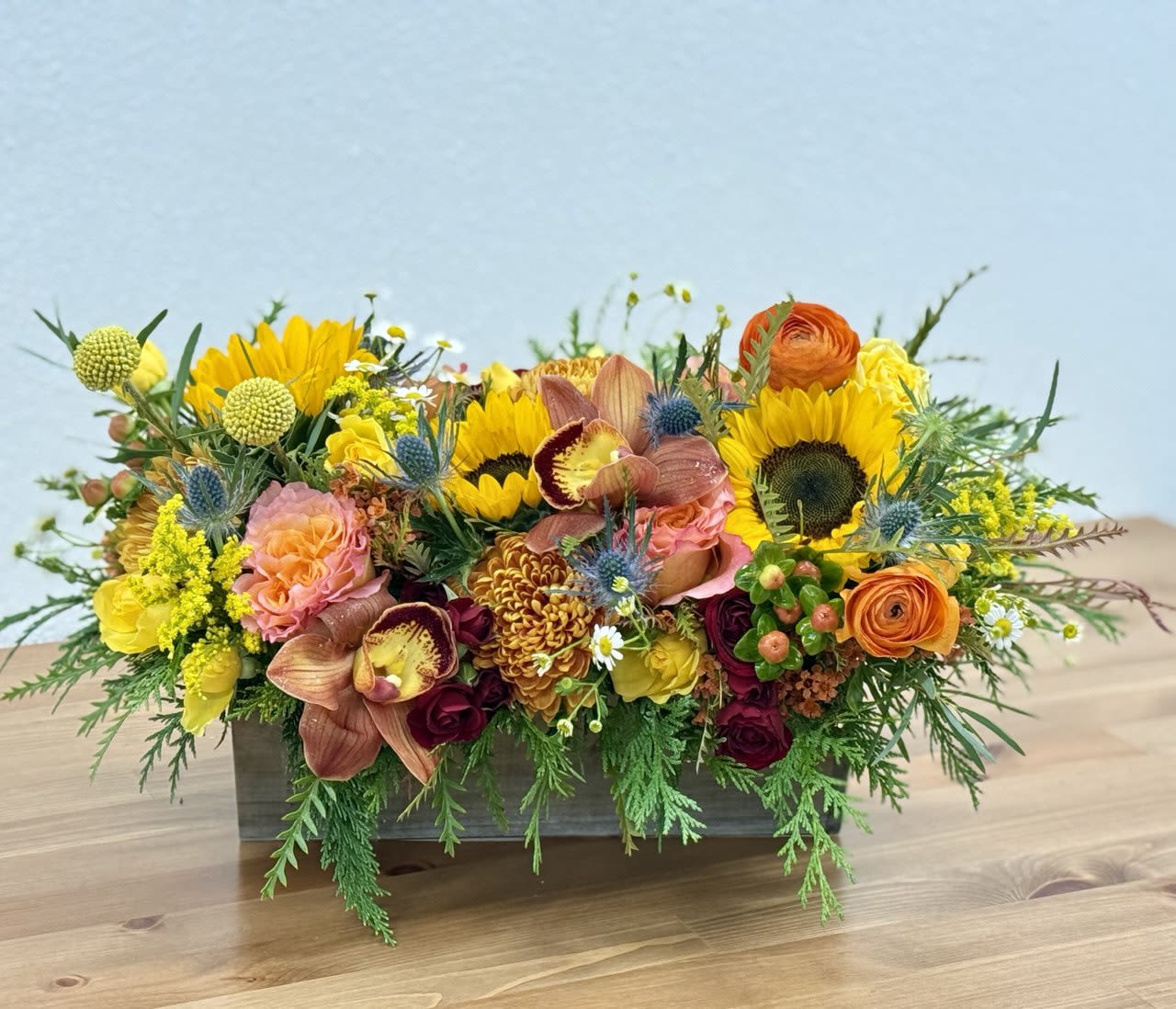 Mixed floral arrangement in a rectangular wooden container