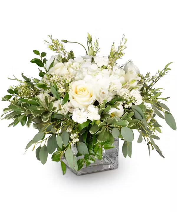 White rose arrangement in a square glass vase with mixed greenery