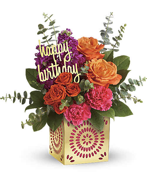 Birthday flower arrangement with roses, carnations, and a "happy birthday" sign in a gift box