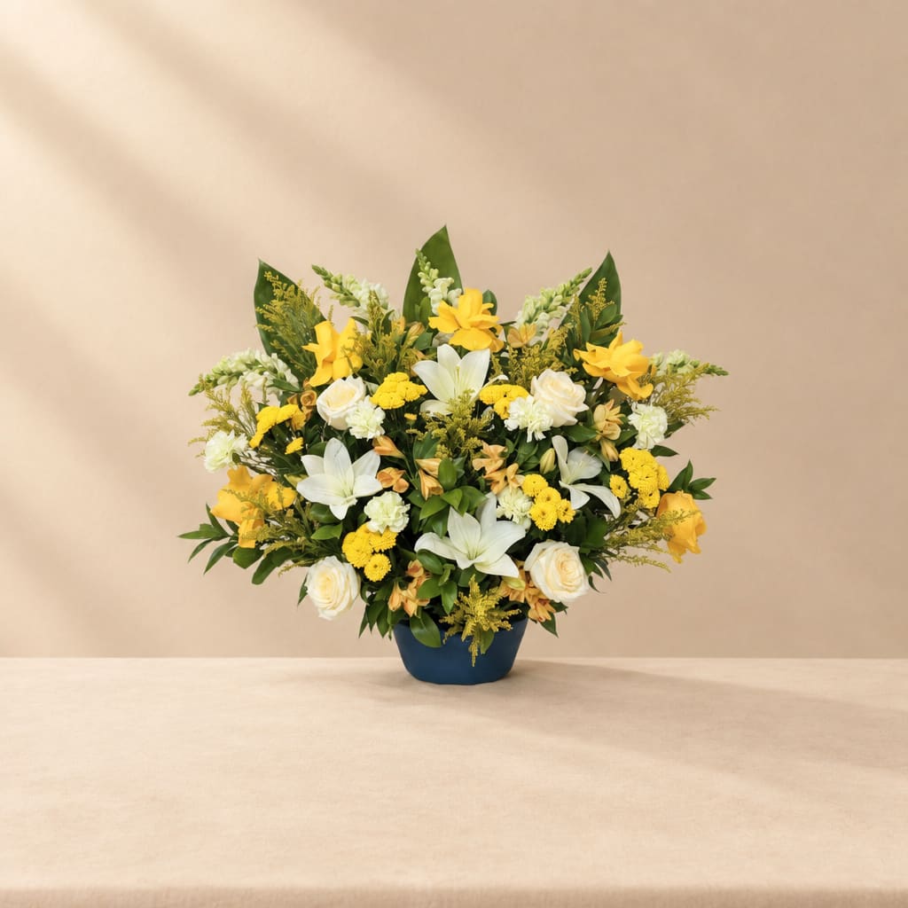 Yellow and white floral arrangement in a blue vase