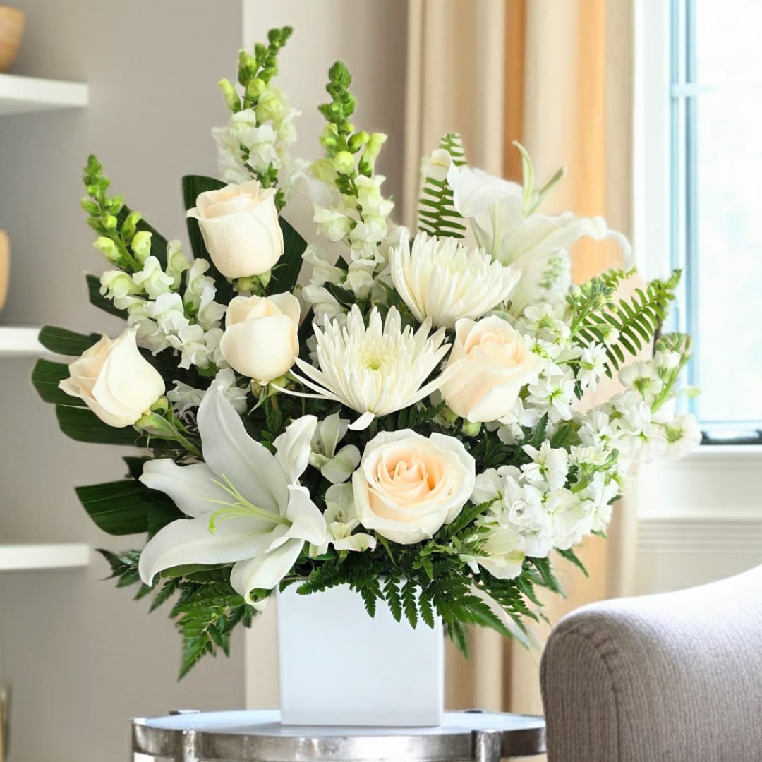 White roses and lilies arranged in a white vase