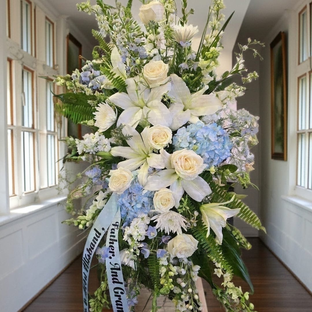 Large white and blue floral standing spray with lilies and roses
