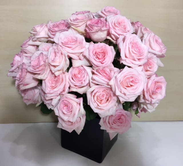 Bouquet of pale pink roses in a black box vase