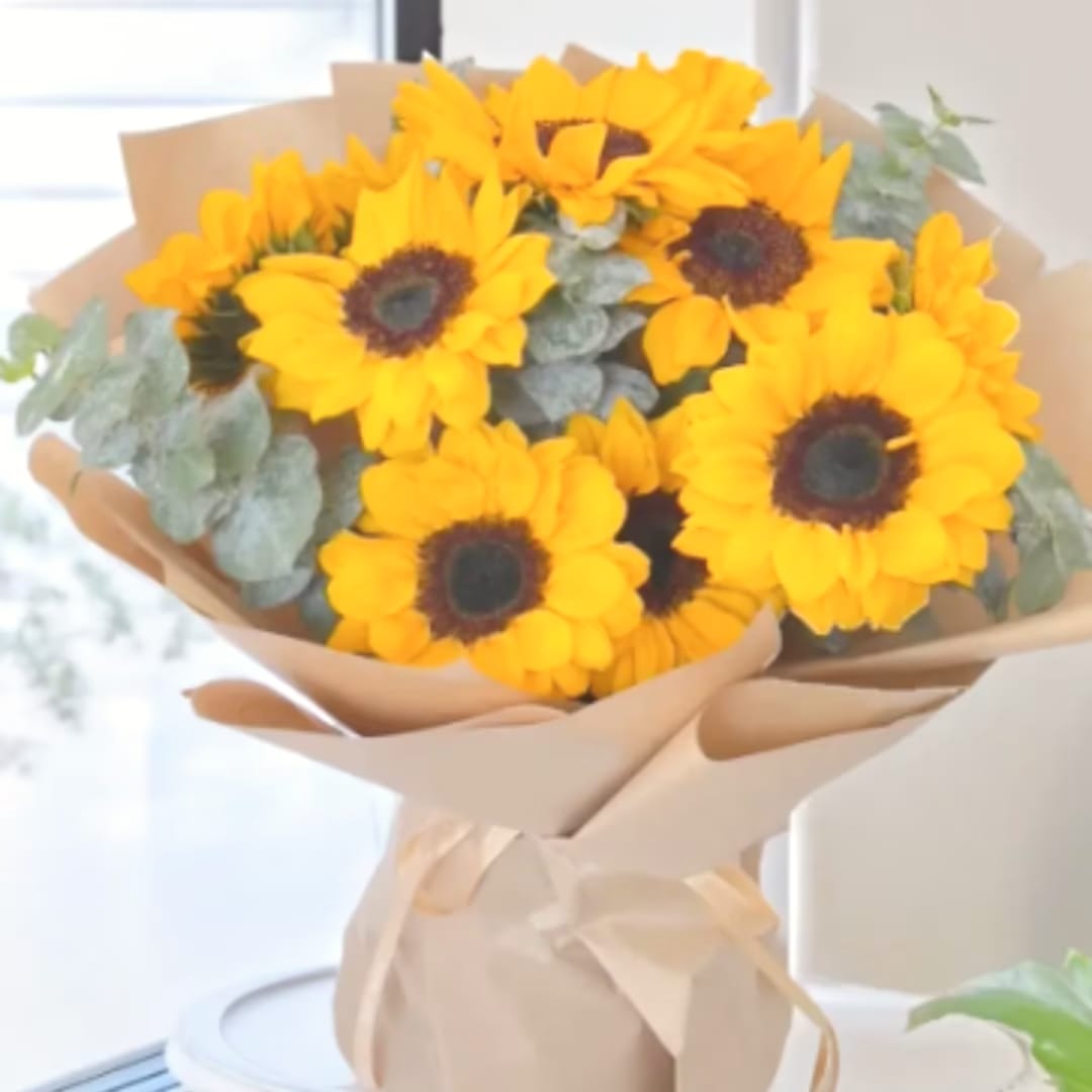 Bouquet of yellow sunflowers wrapped in beige paper