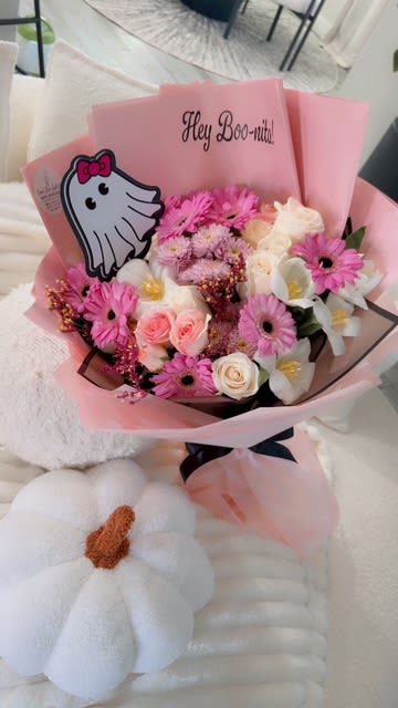 Pink bouquet with roses, daisies, and white flowers in pink wrap