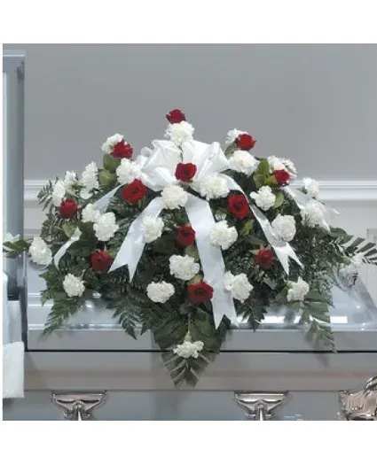 Red and white floral casket spray with ribbon