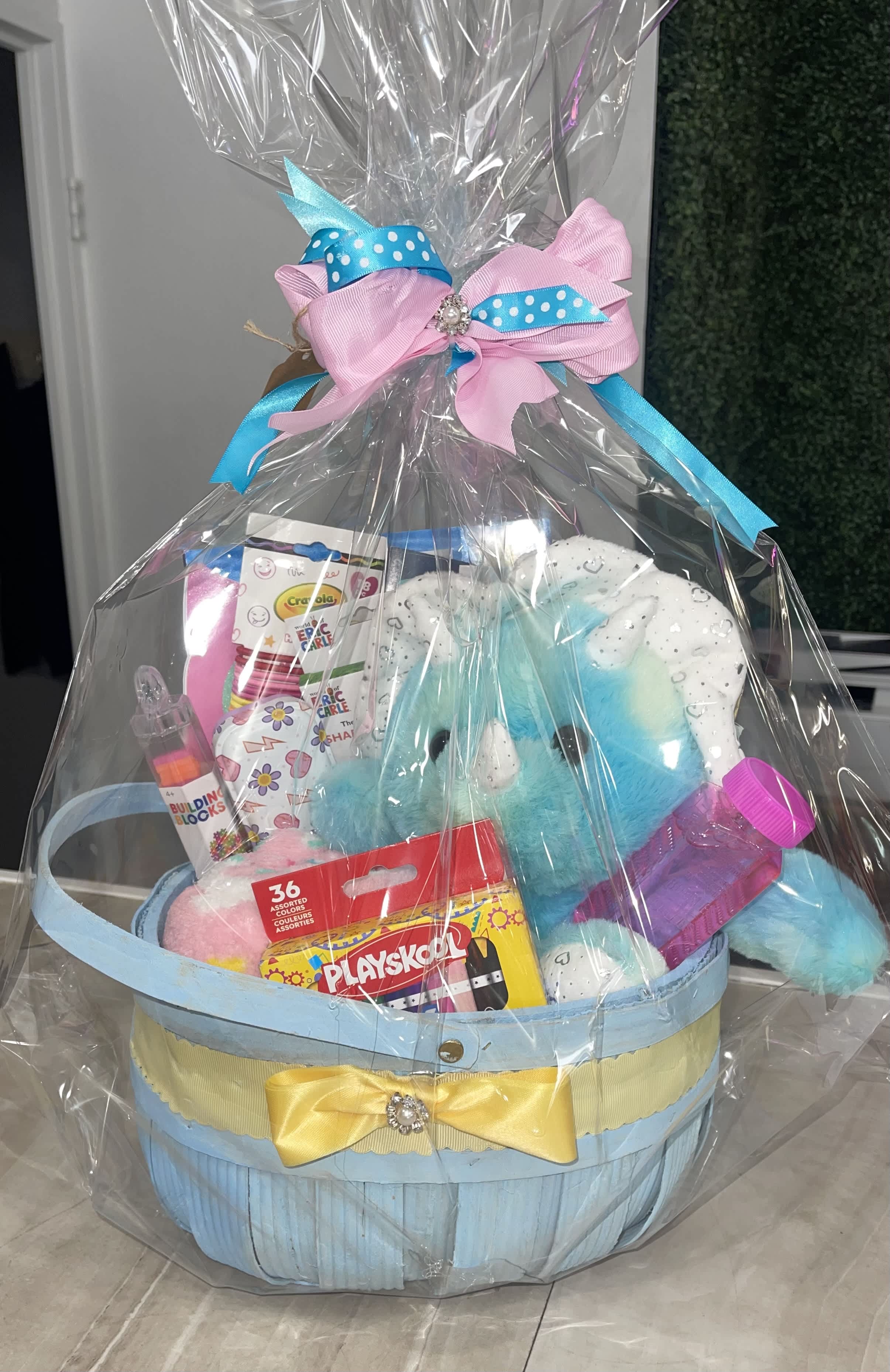 Gift basket with plush toys and crayons wrapped in clear plastic