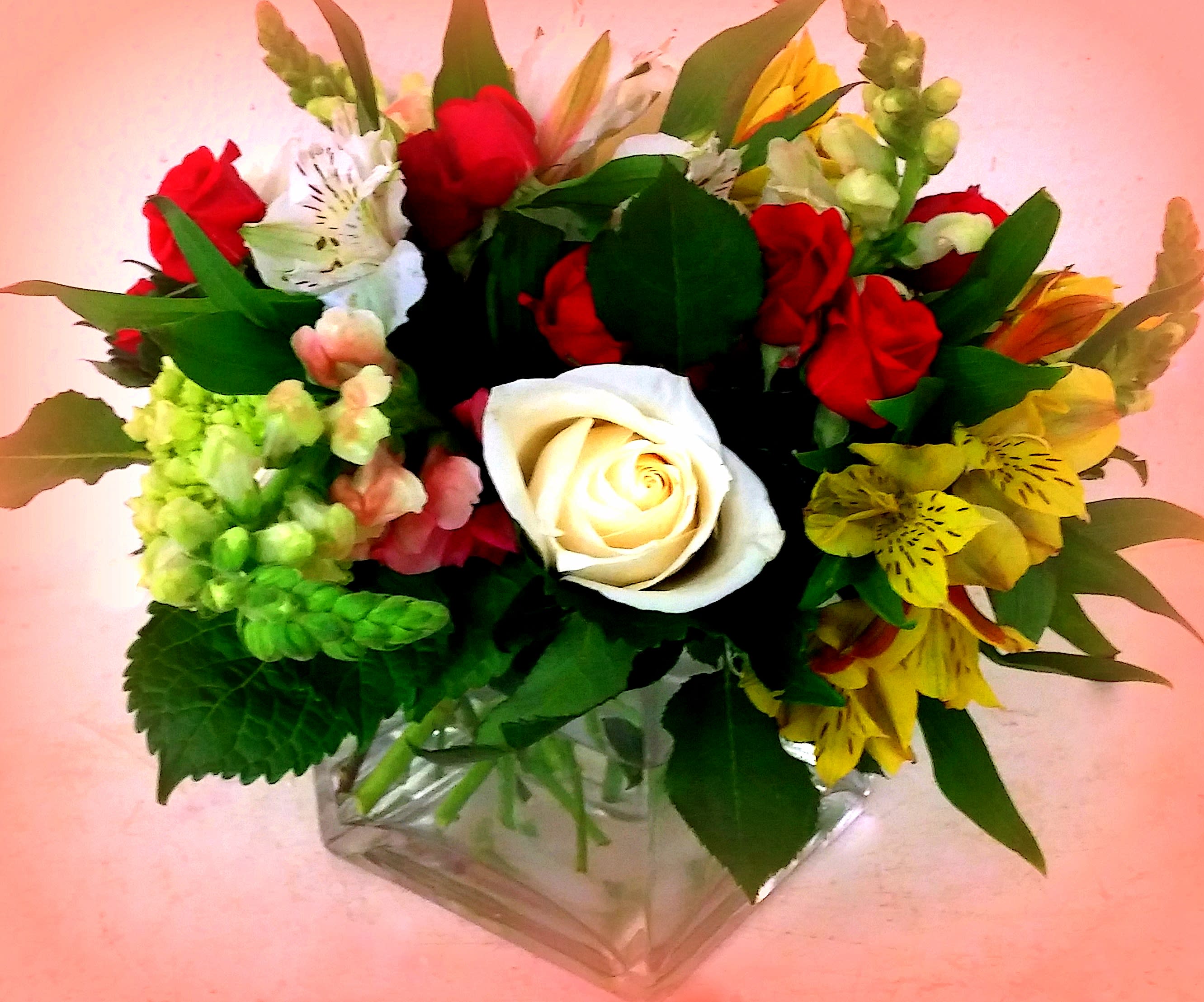 Mixed bouquet with red and white roses in a clear glass vase