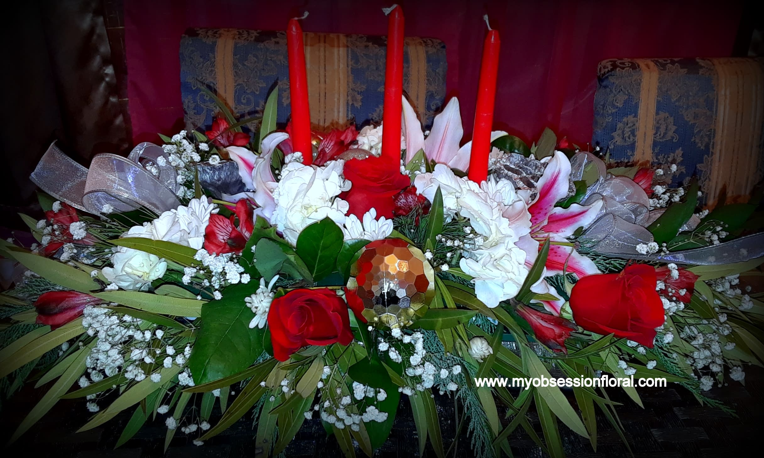 Red and white floral centerpiece with tall red candles