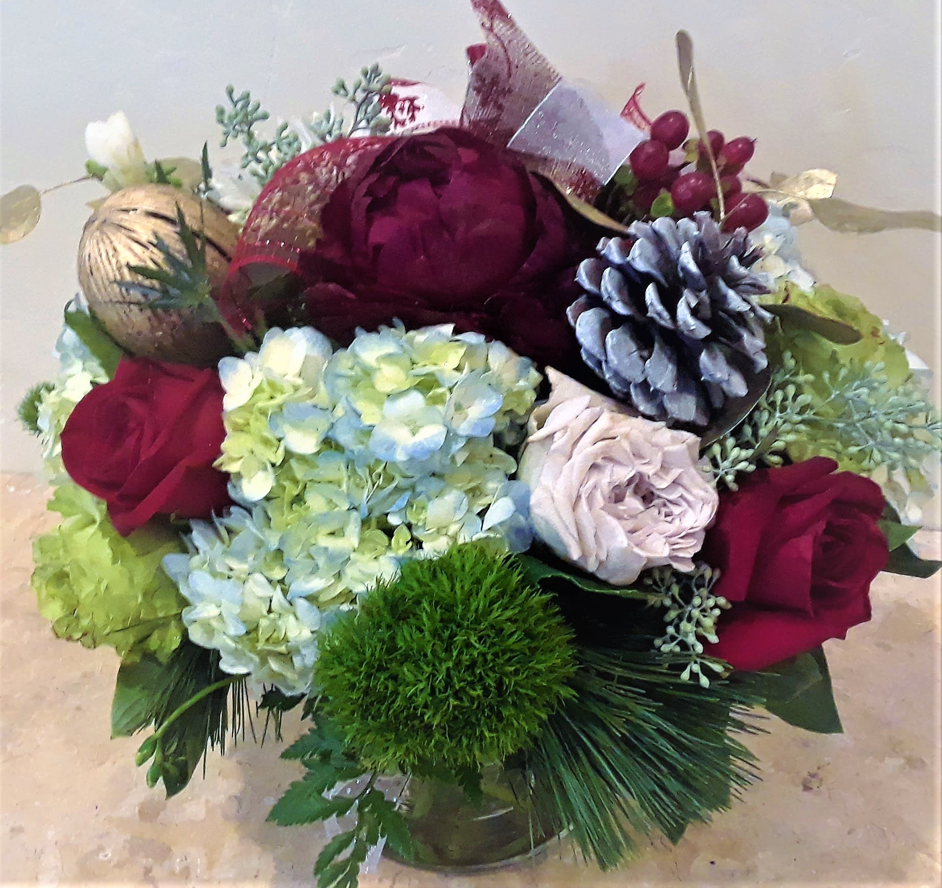 Bouquet of burgundy roses and blue hydrangeas with pinecones