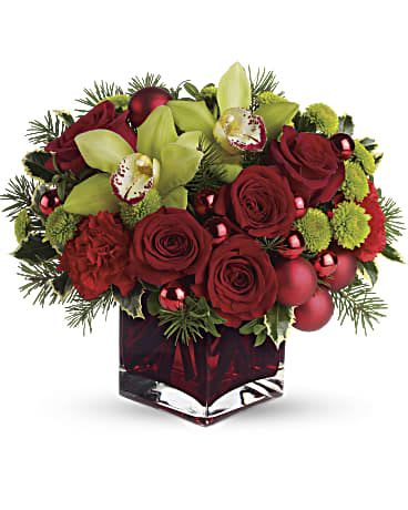 Red roses and green orchids in a square glass vase