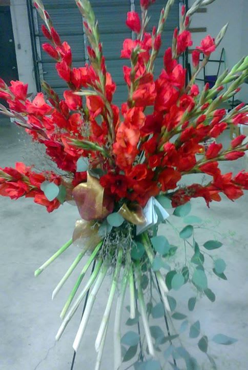 Tall bouquet of red gladiolus with trailing eucalyptus