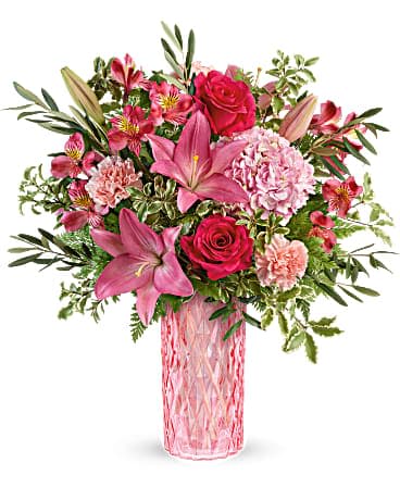 Pink floral arrangement in a tall glass vase