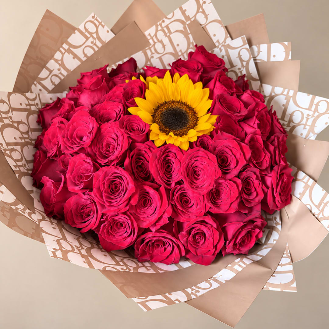 Bouquet of hot pink roses with a yellow sunflower center