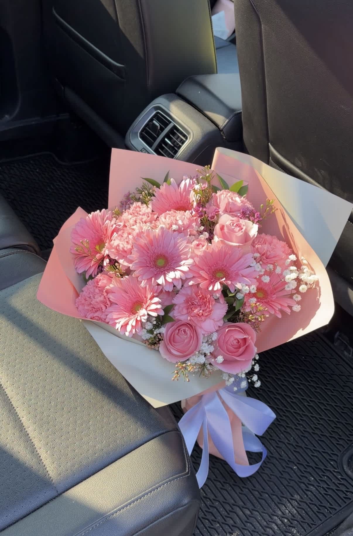 Pink bouquet with gerbera daisies and roses wrapped in pastel paper