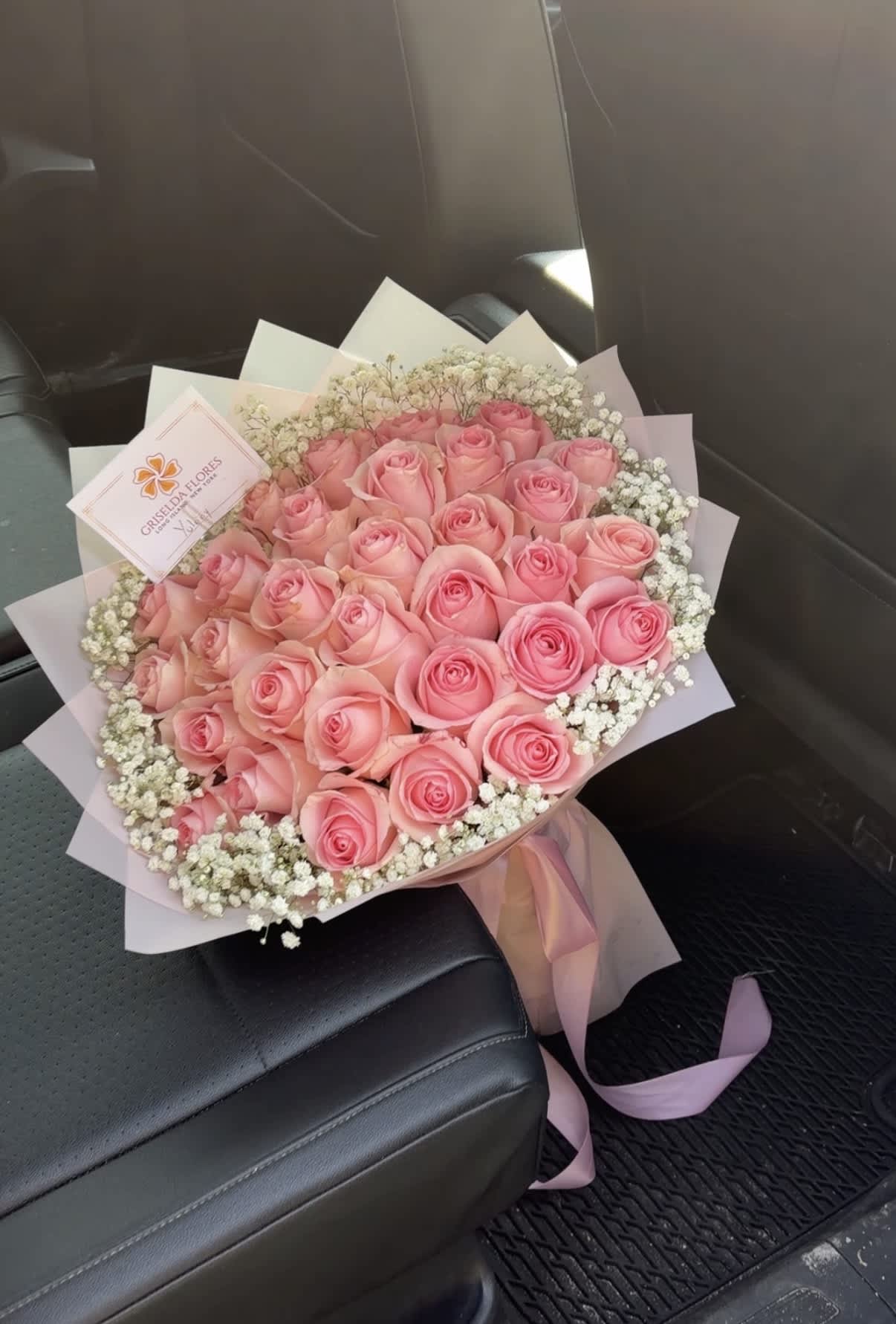 Bouquet of pink roses with white baby's breath and pink wrapping