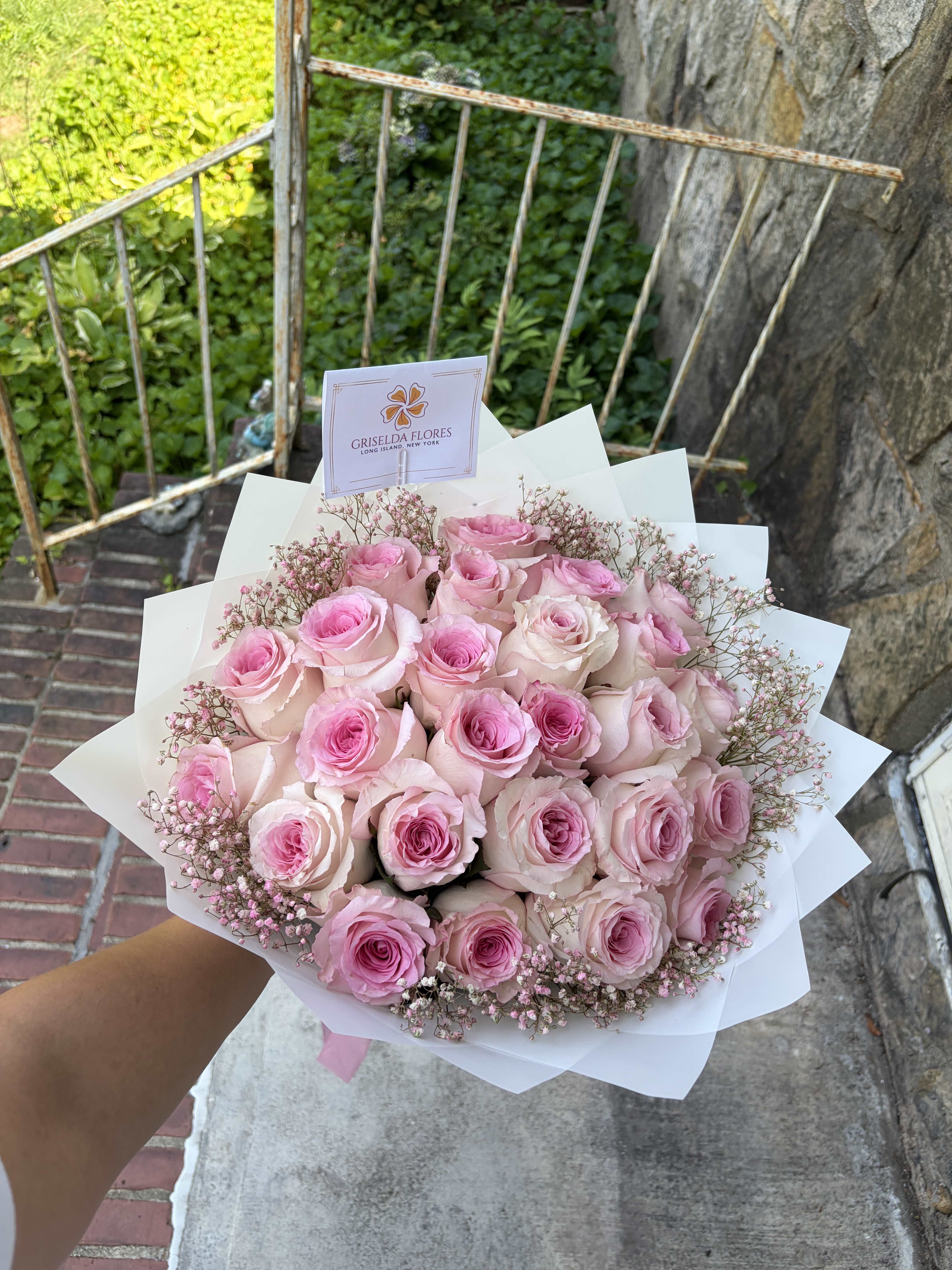 Bouquet of pink roses with baby's breath in white wrap