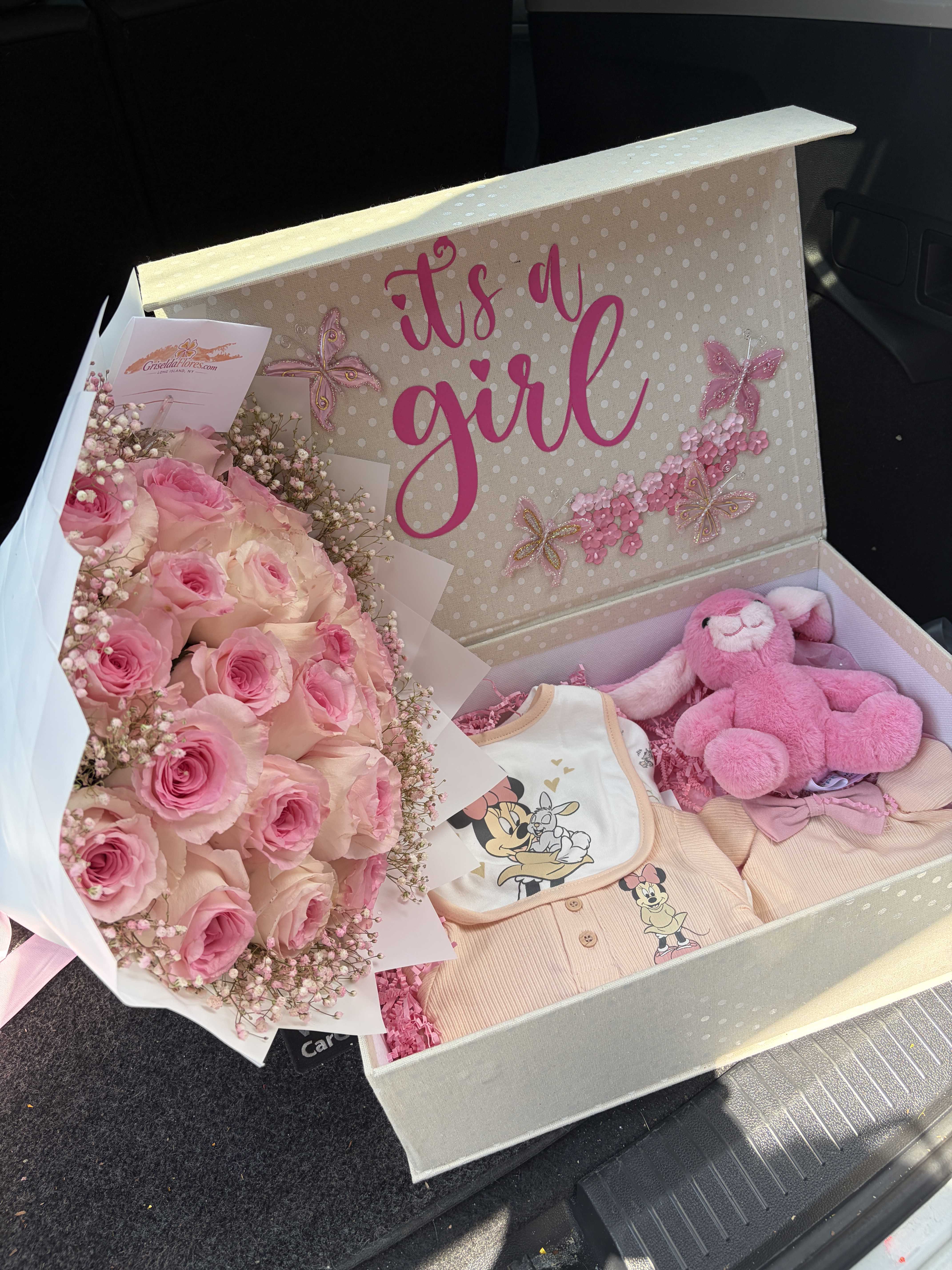 Pink rose bouquet with a plush bunny and baby clothes in a gift box