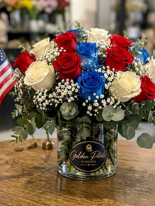 Bouquet of red, white, and blue roses in a glass vase