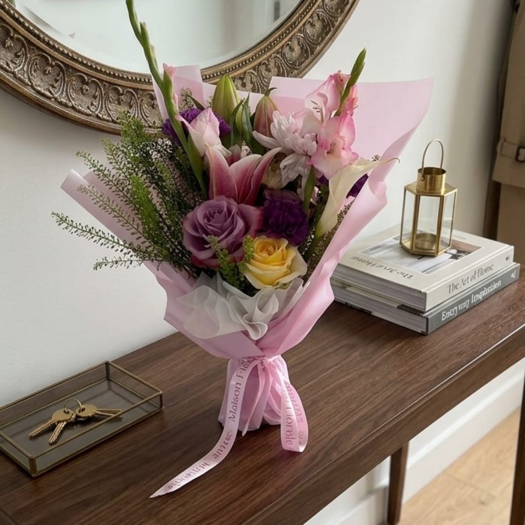 Pink and purple mixed bouquet wrapped in pink paper with a ribbon