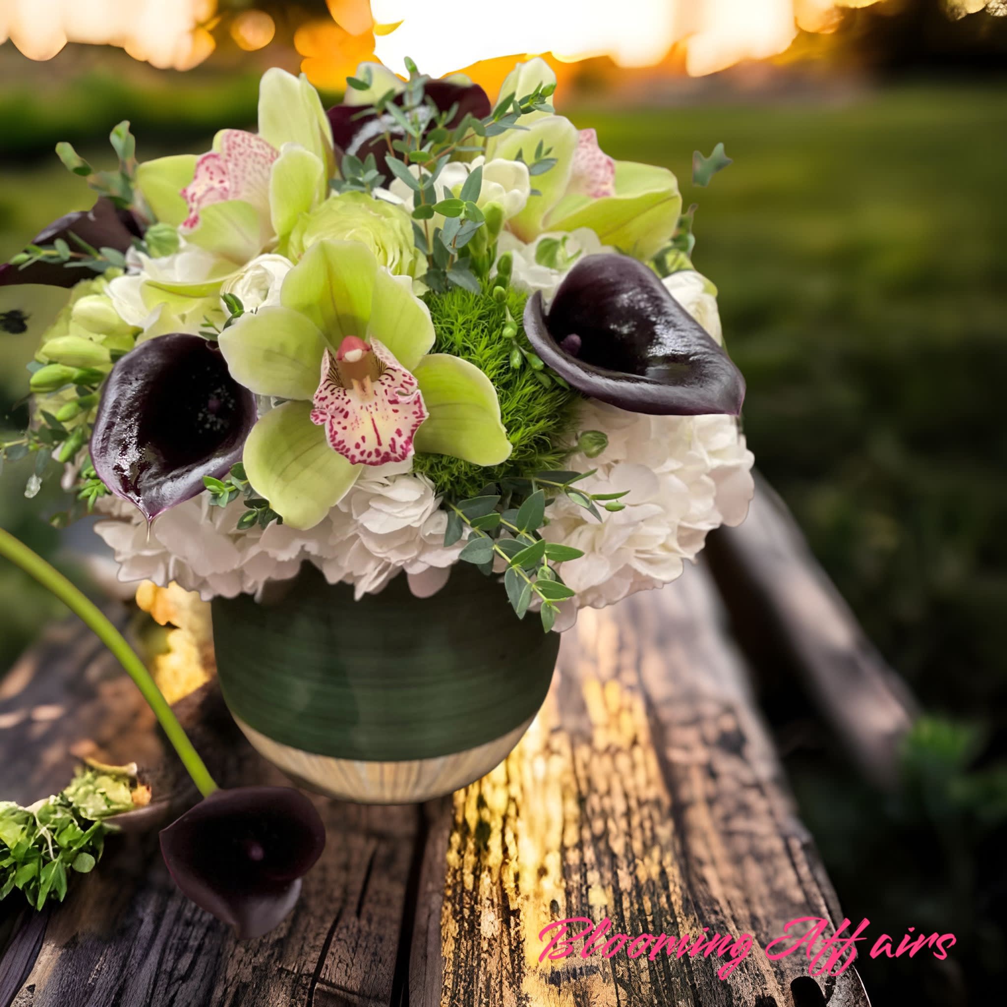 Bouquet of green orchids, white hydrangeas, and dark calla lilies in a vase