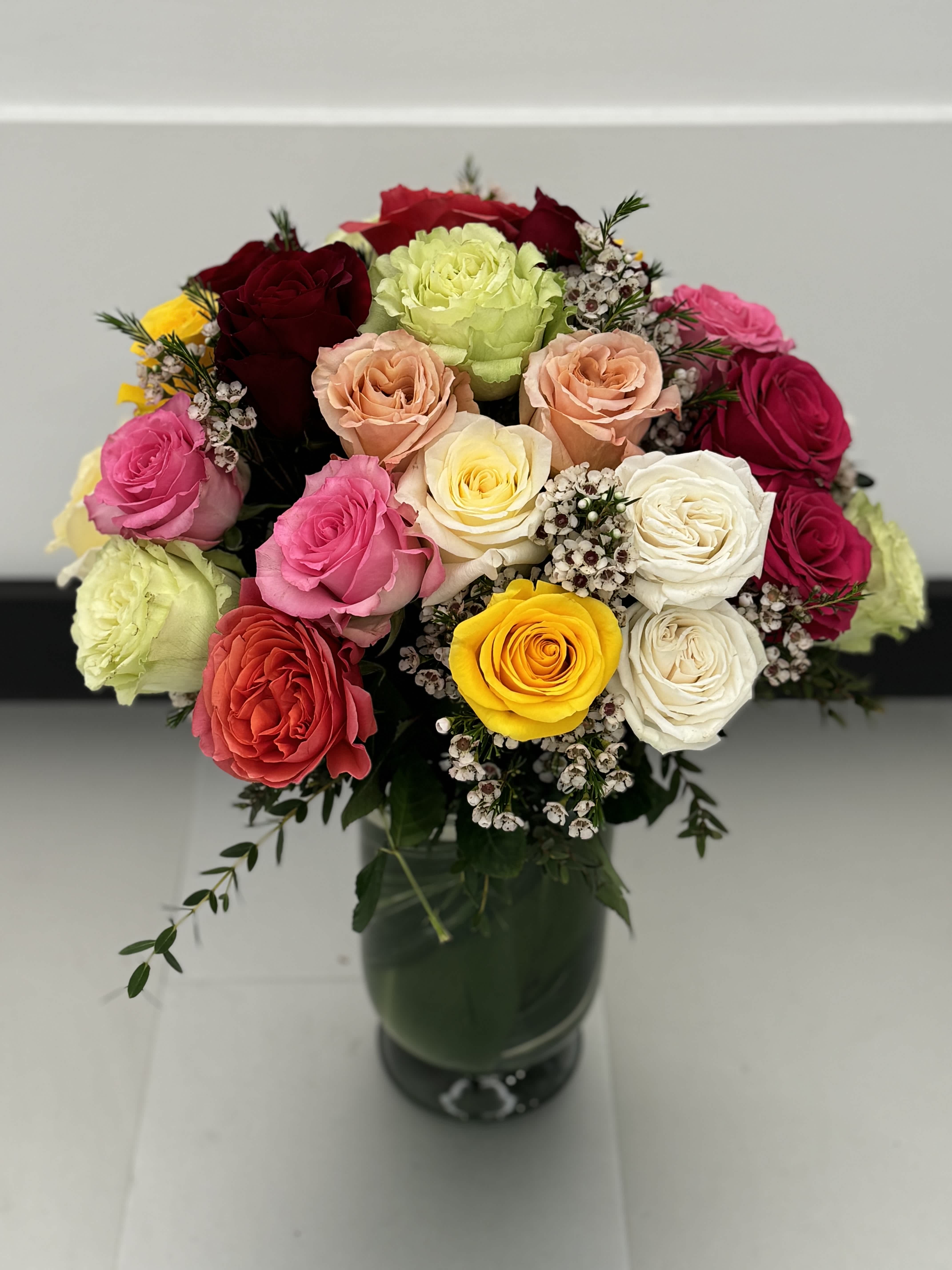 Mixed rose bouquet in a dark glass vase
