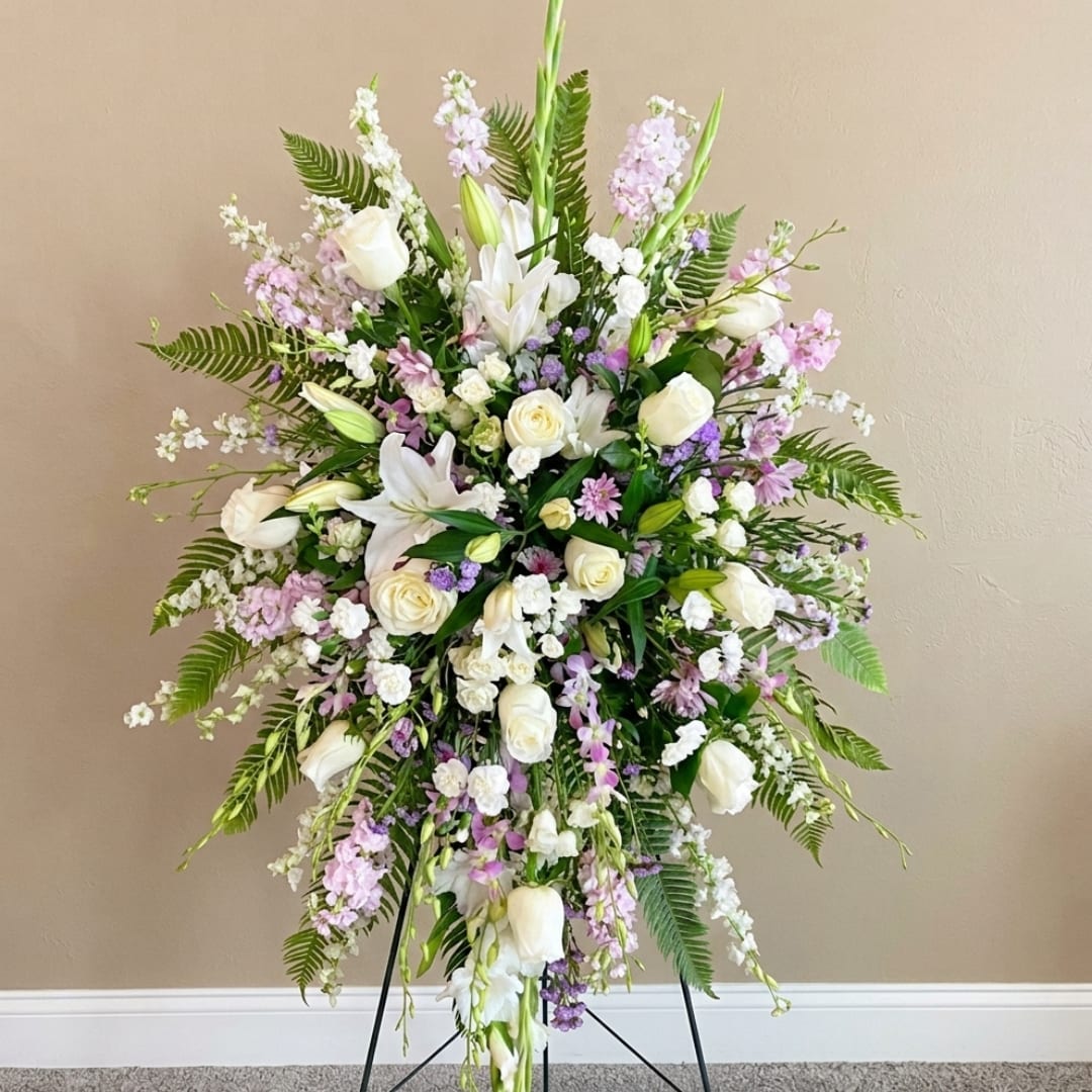 Tall white and lavender floral standing spray on a black easel
