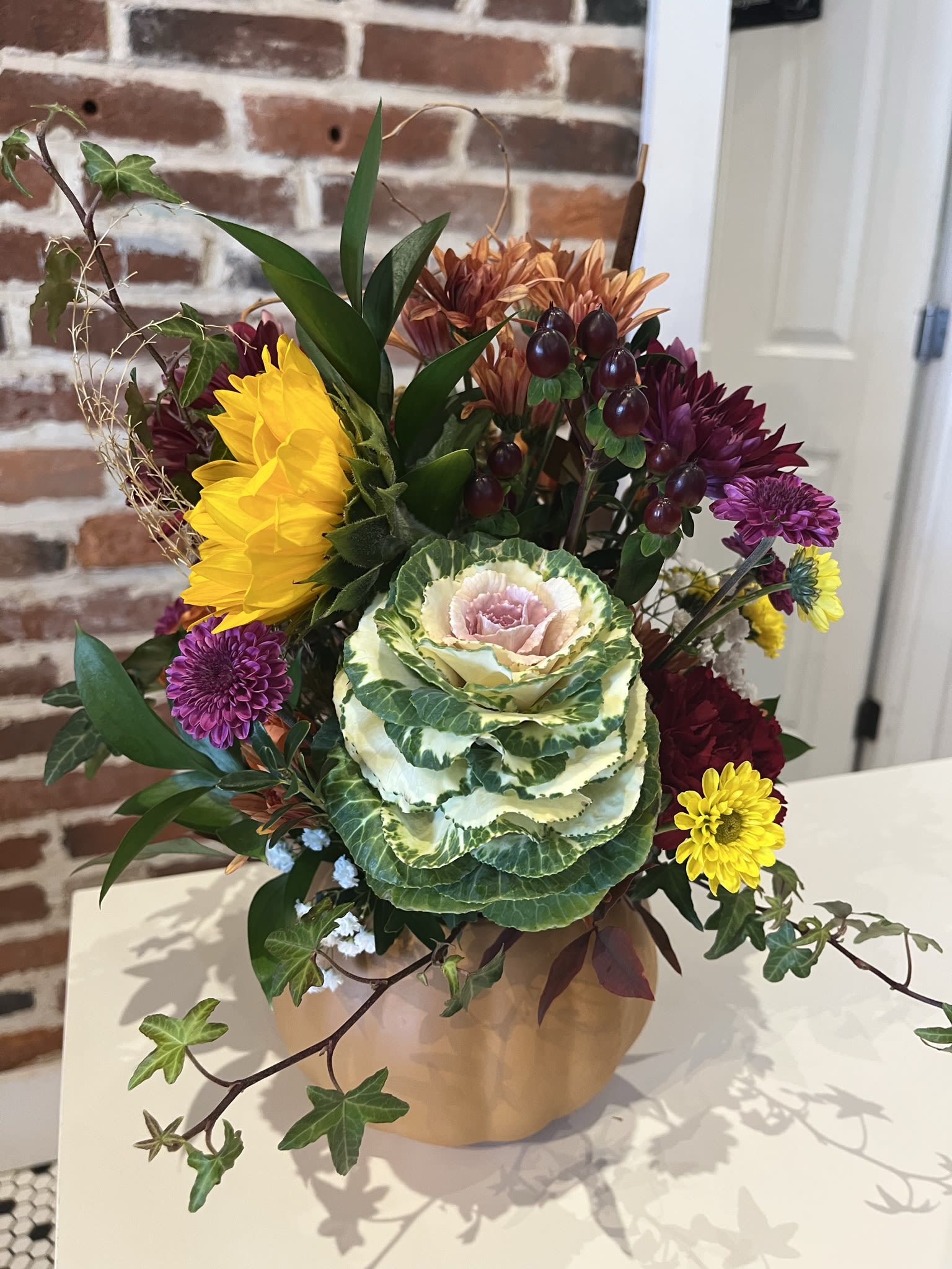 Timeless Thanksgiving - A ceramic pumpkin filled with seasonal flowers, grasses, and greens ready to grace a table for a celebration of Thanksgiving.  