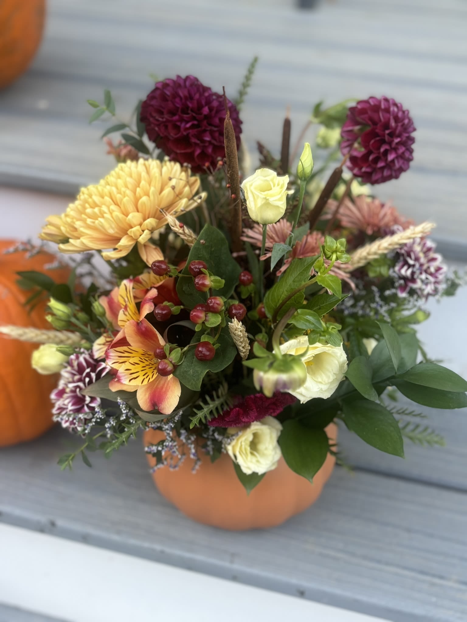 Pumpkin Patch - Celebrate the season with a handcrafted fall arrangement designed in an 8" ceramic pumpkin. Each piece features locally grown blooms and natural autumn textures. Because we use the freshest flowers available, every arrangement is one-of-a-kind—bursting with the rich colors and charm of fall.