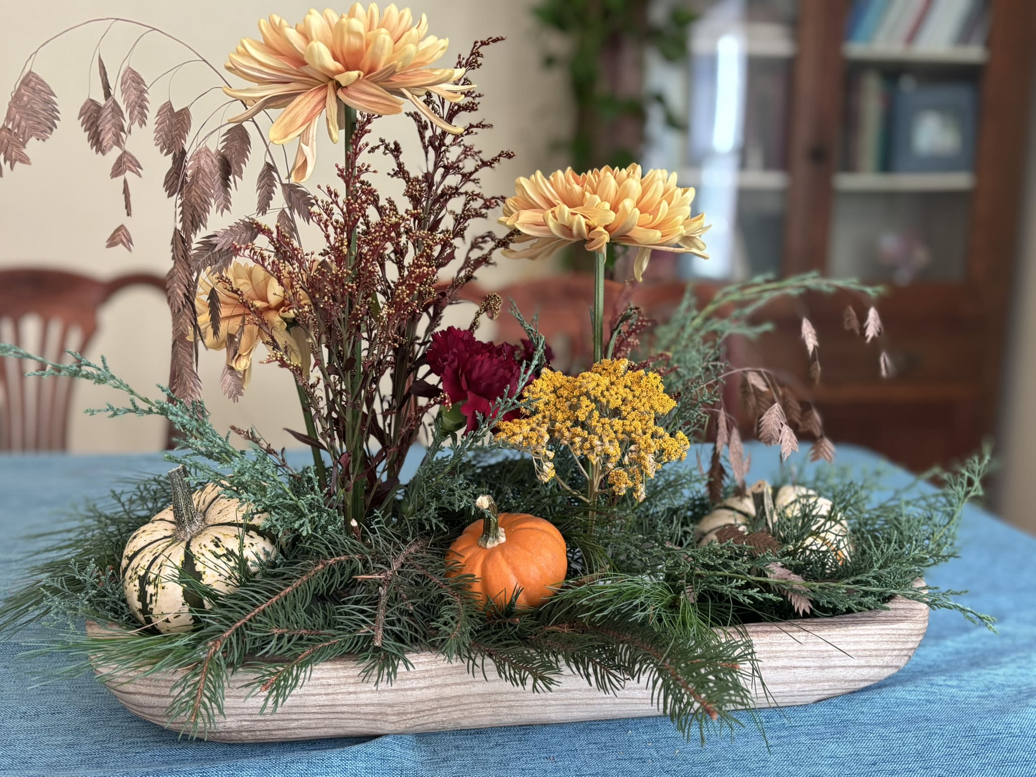 Ikebana Mums - A 15" shallow wooden bowl with two smaller bowls holding coordinating ikebana arrangements.   Fresh evergreens and mini pumpkins surround the Ikebana bowls.   