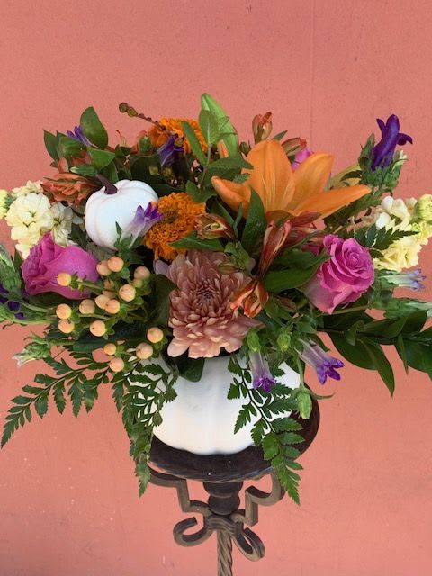 Mixed bouquet in a white vase with orange, pink, purple, and white flowers
