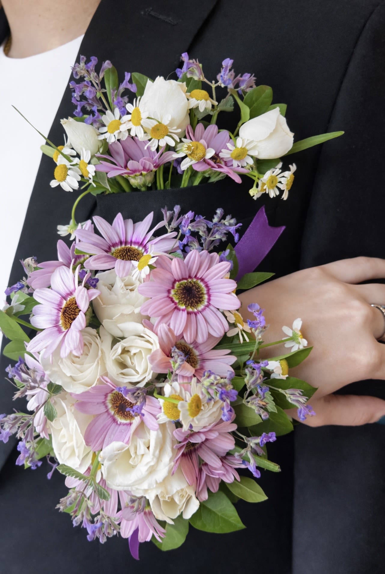 Pink daisies and white roses arranged as a boutonniere and bouquet set