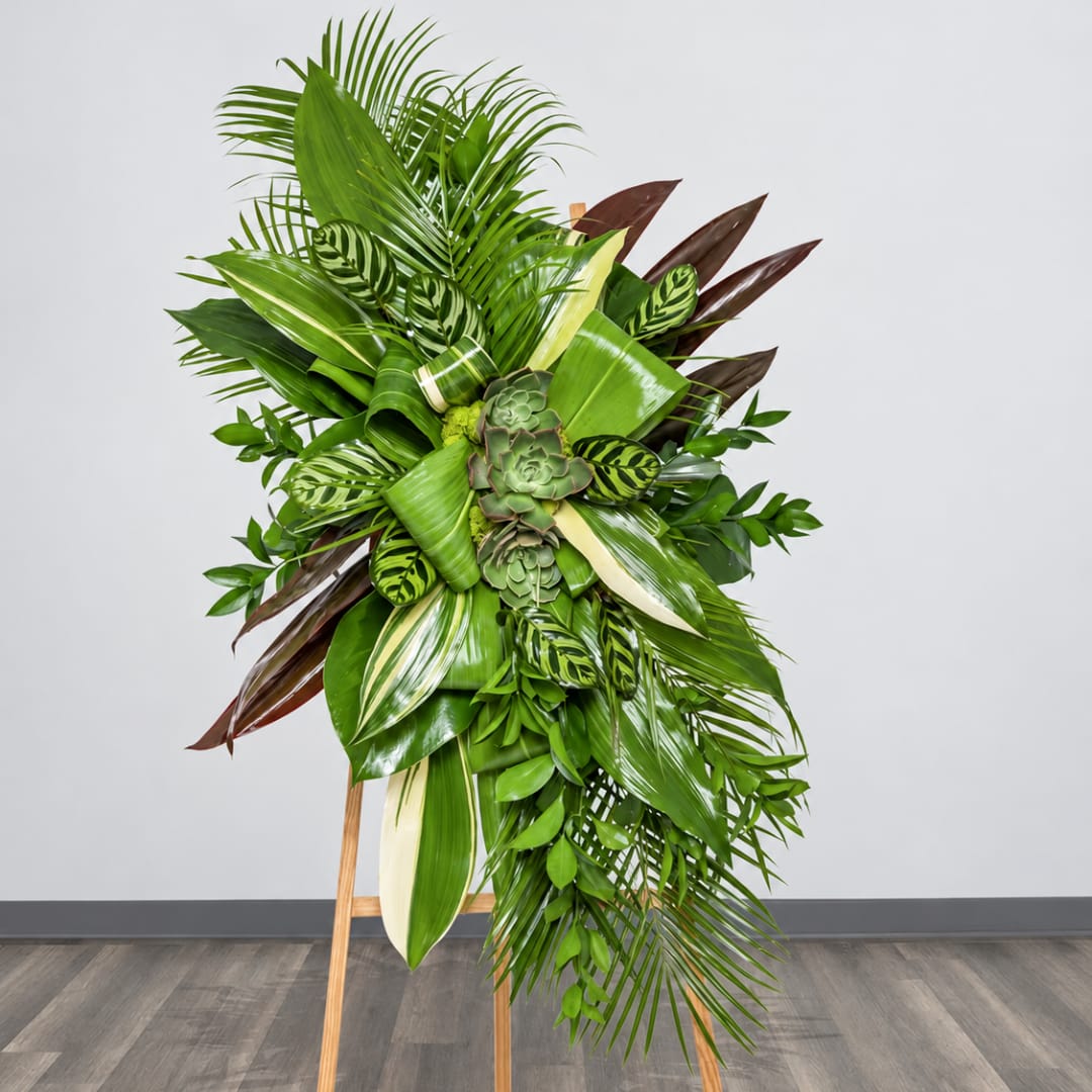 Tall tropical plant arrangement on a wooden easel with layered green foliage