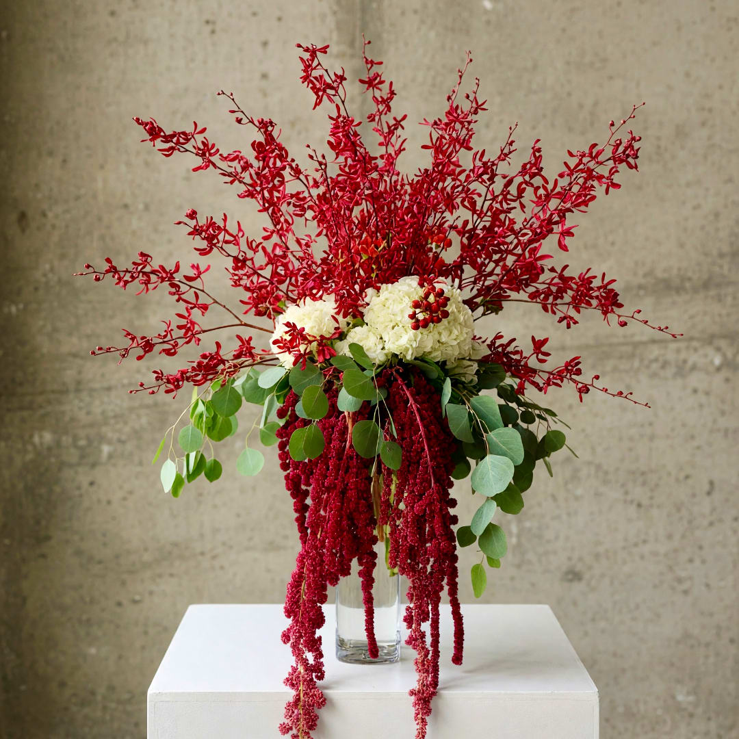 Tall red and white floral arrangement in a clear glass vase