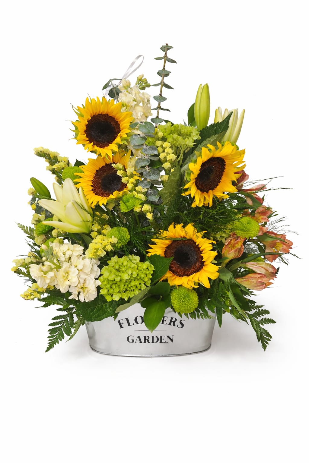 Mixed arrangement of sunflowers, white lilies, and green blooms in a white metal container.