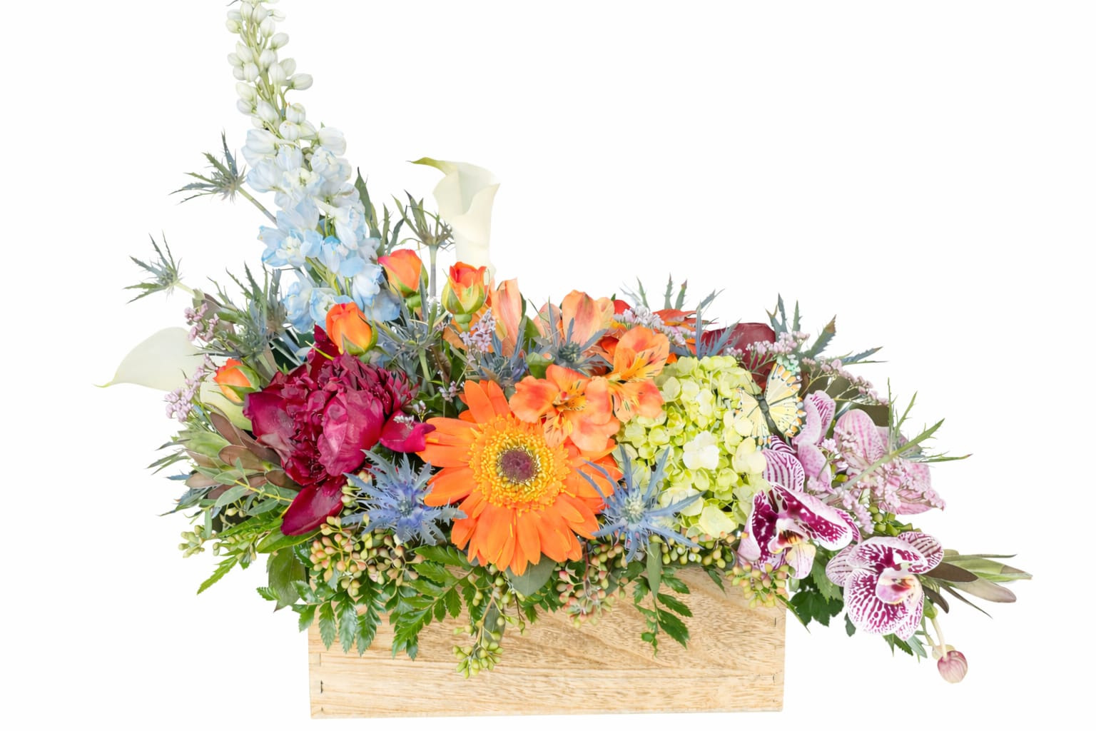 Mixed floral arrangement in a wooden box with orange, blue, and pink blooms