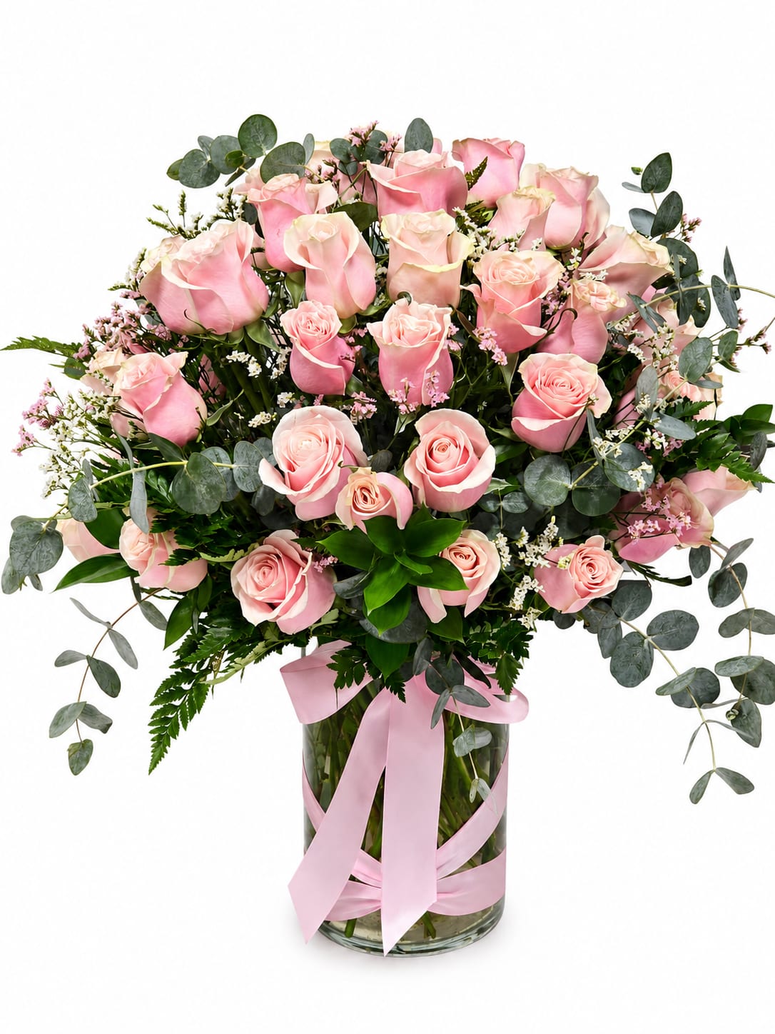 The Grand Blush Roses - The Grand Blush is a breathtaking arrangement featuring 50 premium blush pink roses, beautifully accented with fresh silver dollar eucalyptus and lush seasonal greenery in a modern clear glass vase. Designed to make an unforgettable impression, this luxurious arrangement is perfect for anniversaries, birthdays, new babies, congratulations, or any occasion that calls for an extraordinary expression of love and appreciation.  Each arrangement is handcrafted by our designers using the freshest farm-direct roses to ensure exceptional beauty and longevity.  Includes:  50 Premium Blush Pink Roses Fresh Eucalyptus ( Shop may sub for another Green if not available )  Premium Seasonal Greenery Clear Glass Cylinder Vase Handcrafted by The Flower Corner