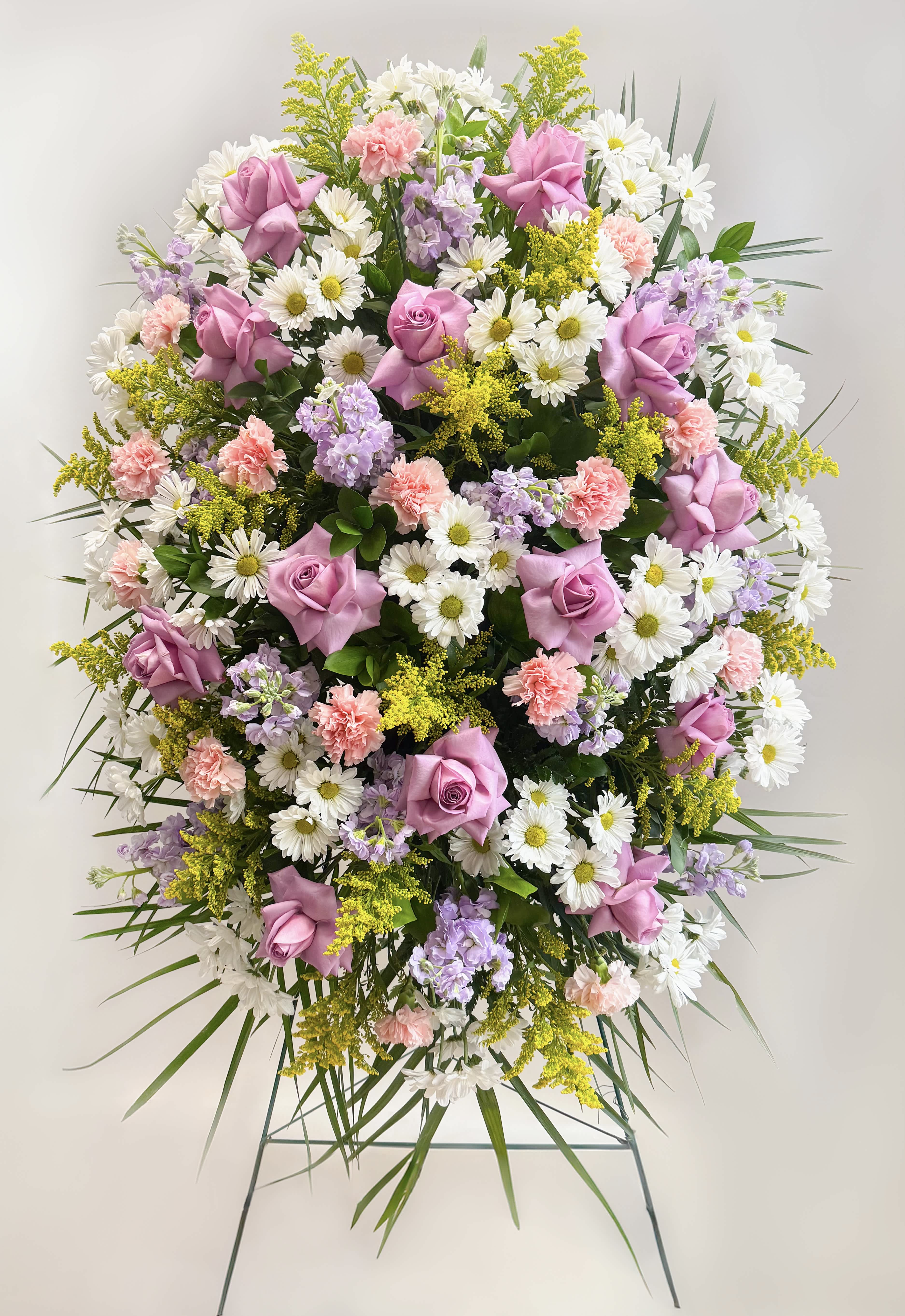 Large standing spray of pink roses, white daisies, and pastel flowers
