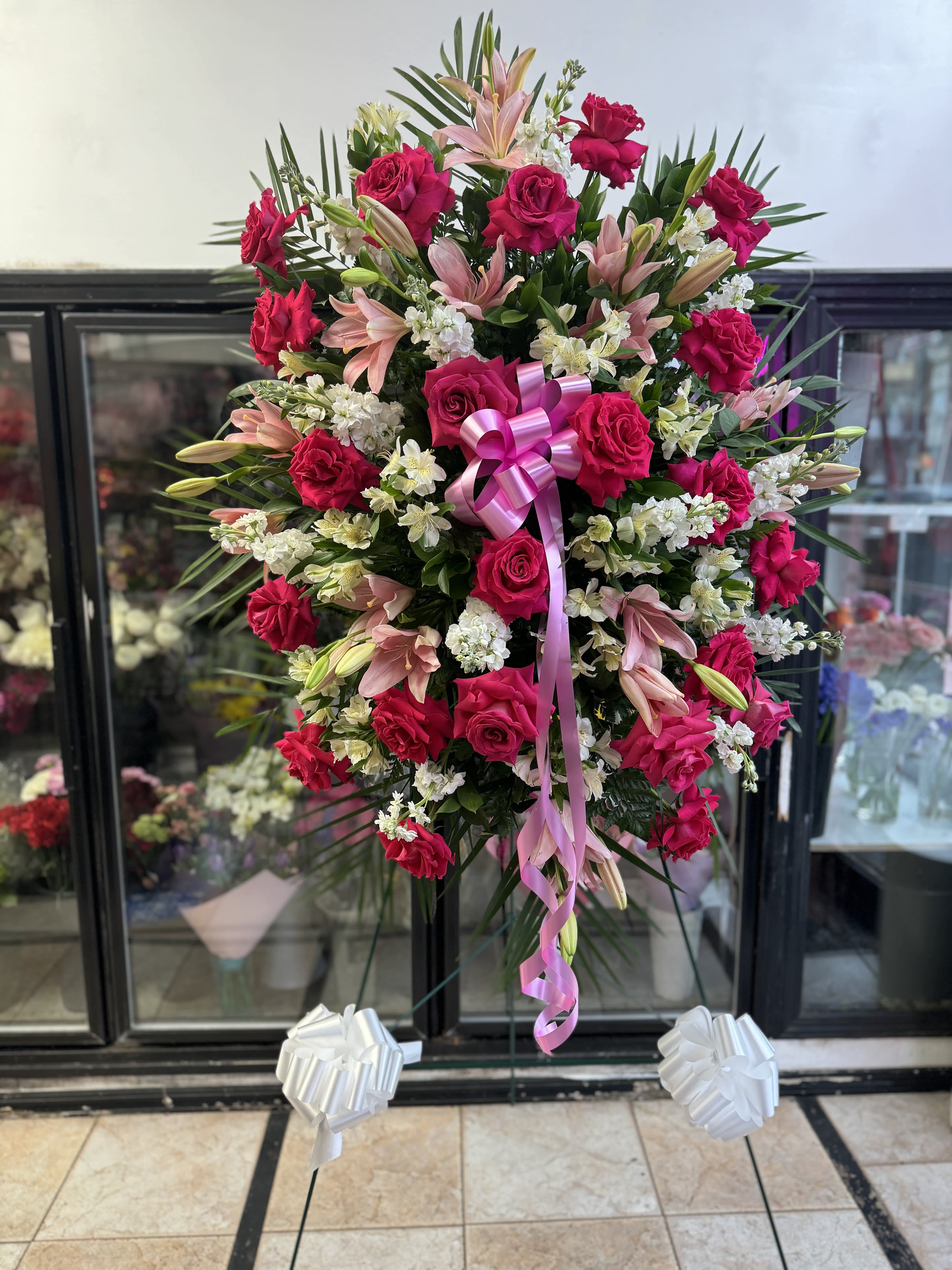 Standing floral spray with pink roses, lilies, and white filler flowers