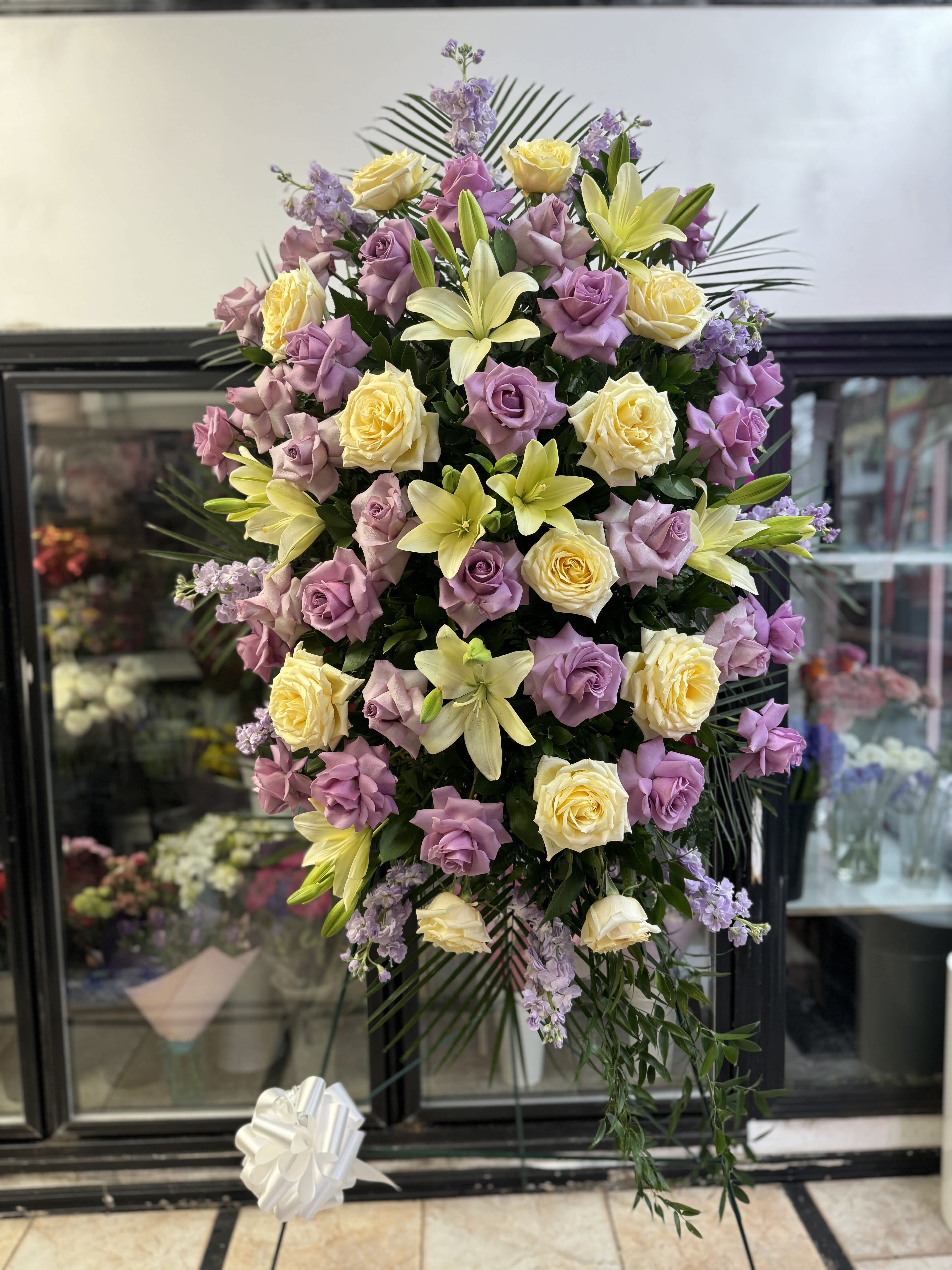 Tall standing floral spray with lavender roses and pale yellow lilies