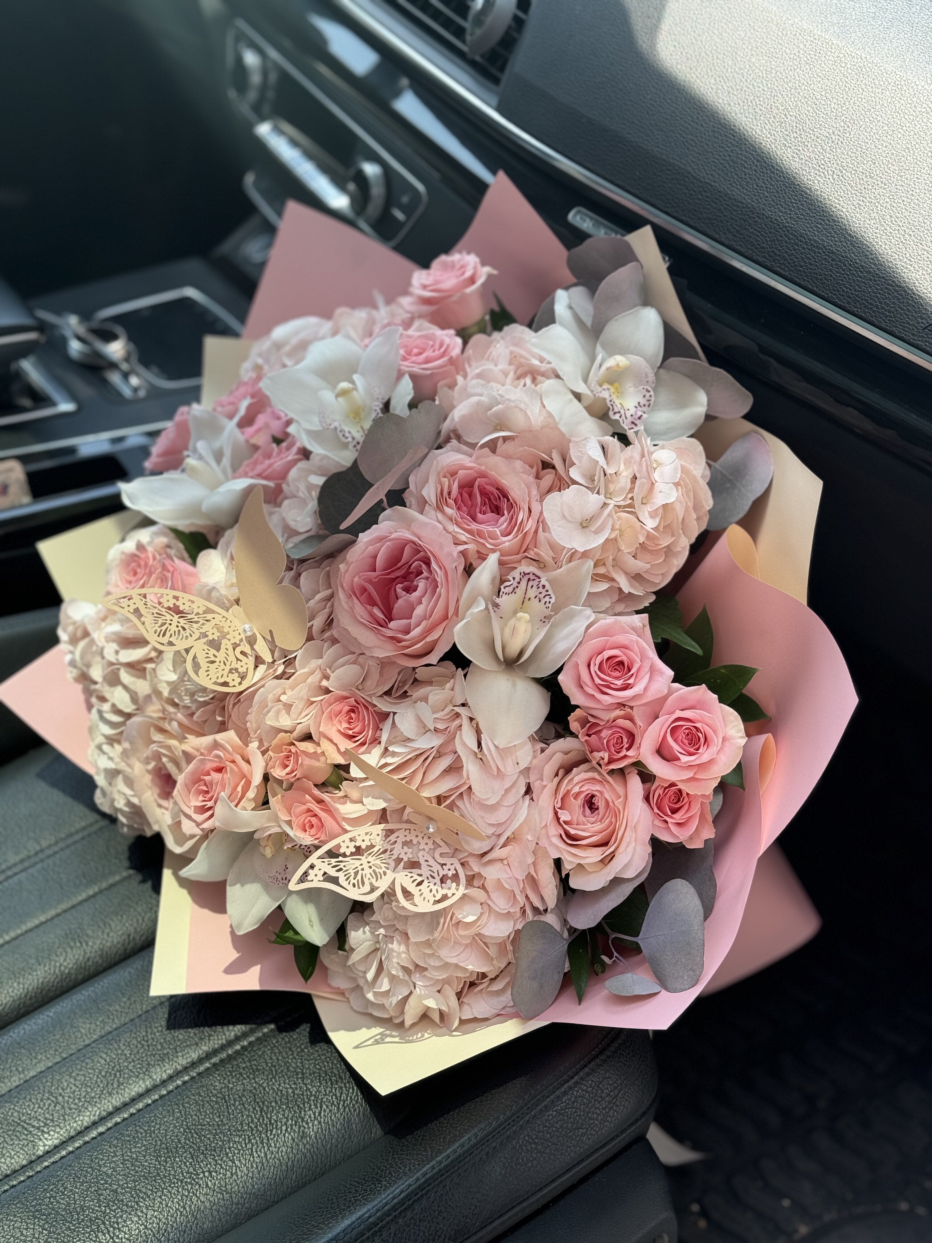 Pink roses and hydrangeas bouquet with white orchids and butterfly accents