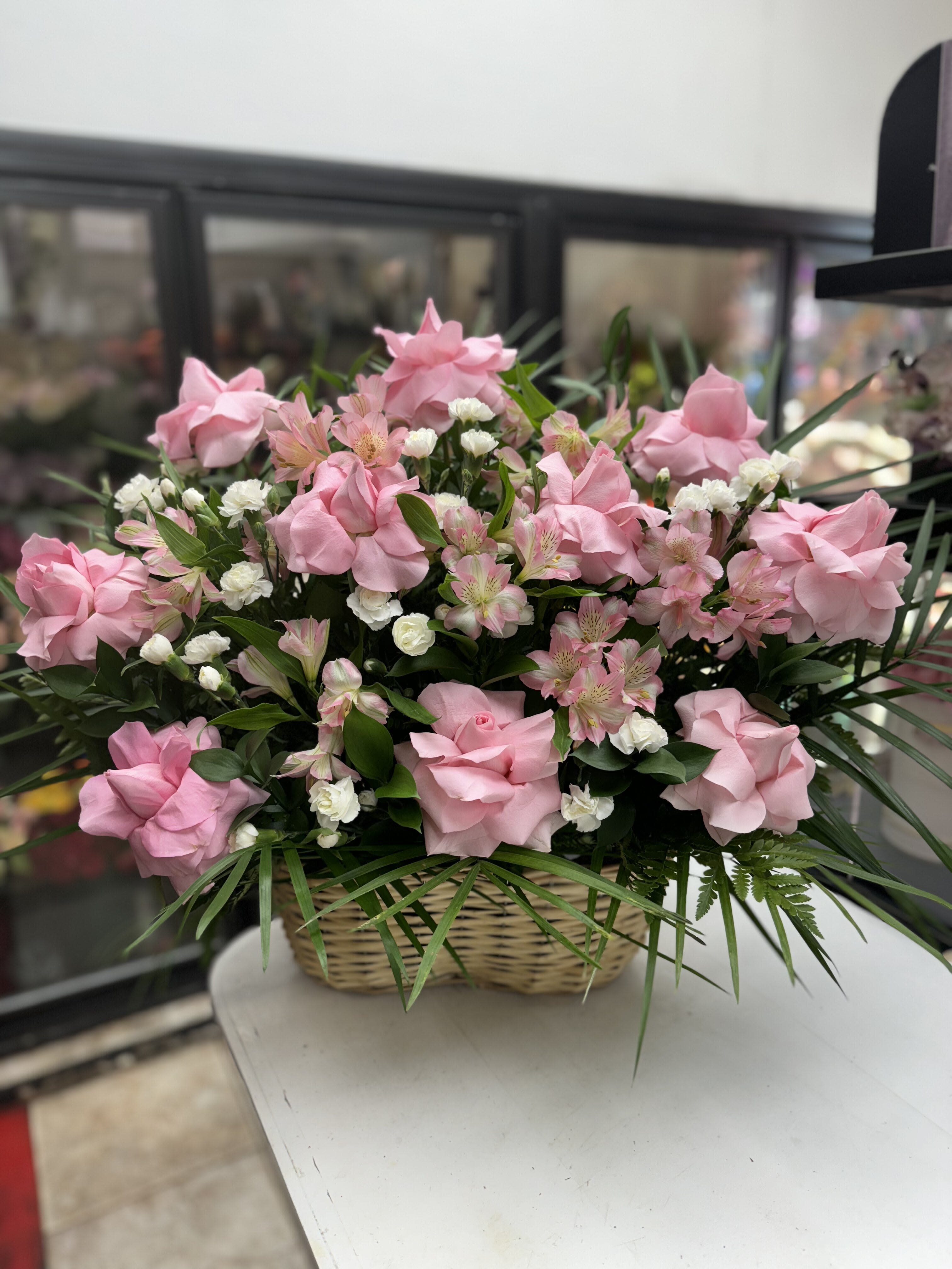 Pink roses and white filler flowers in a wicker basket