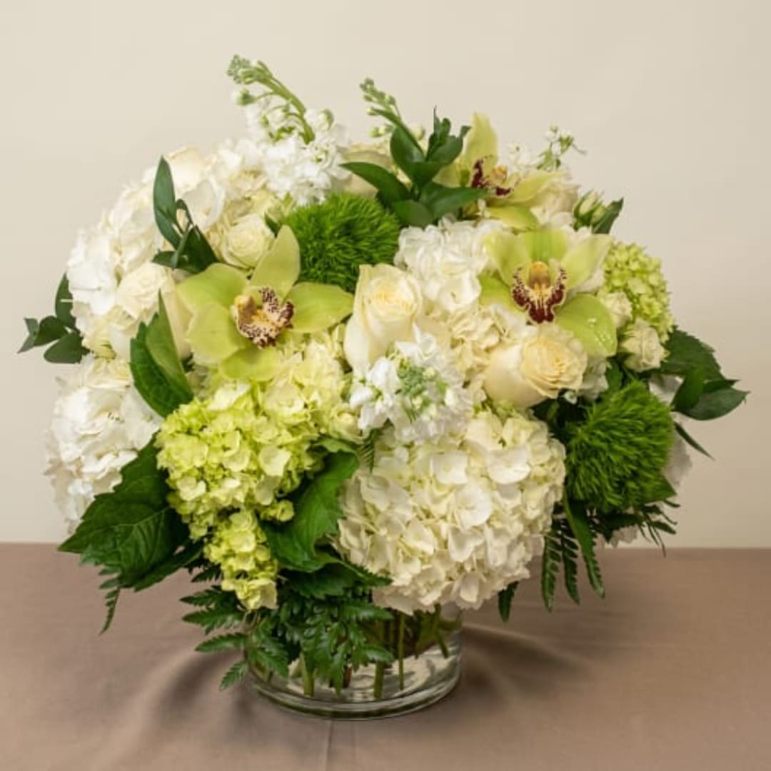White and green floral arrangement in a clear glass vase