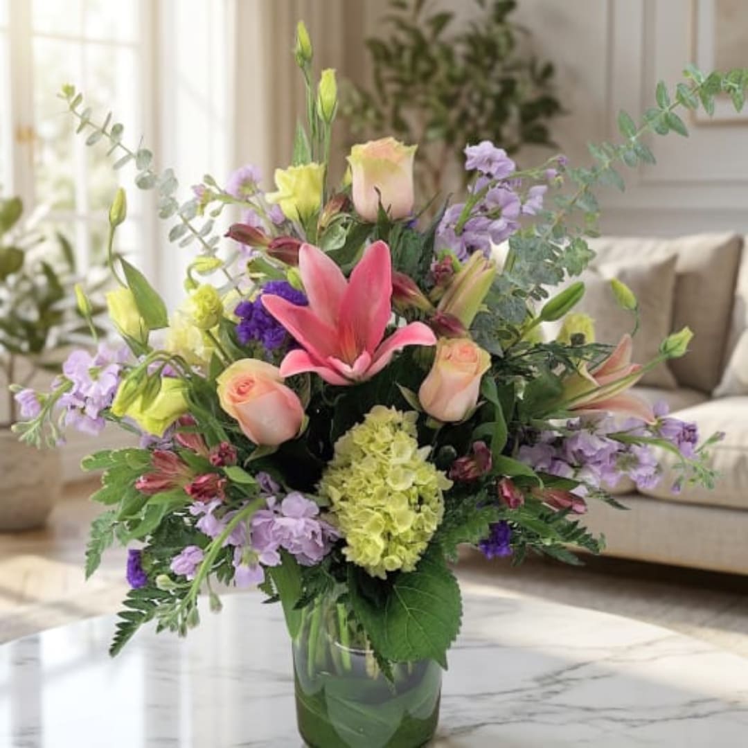 Mixed bouquet with pink lilies and roses in a clear glass vase