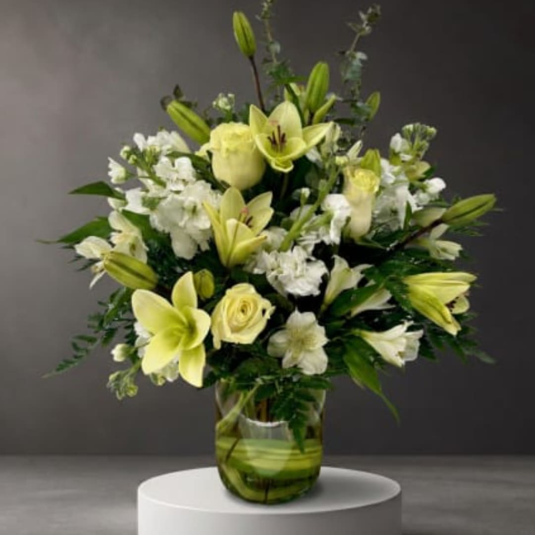 Yellow lilies and white roses in a glass vase