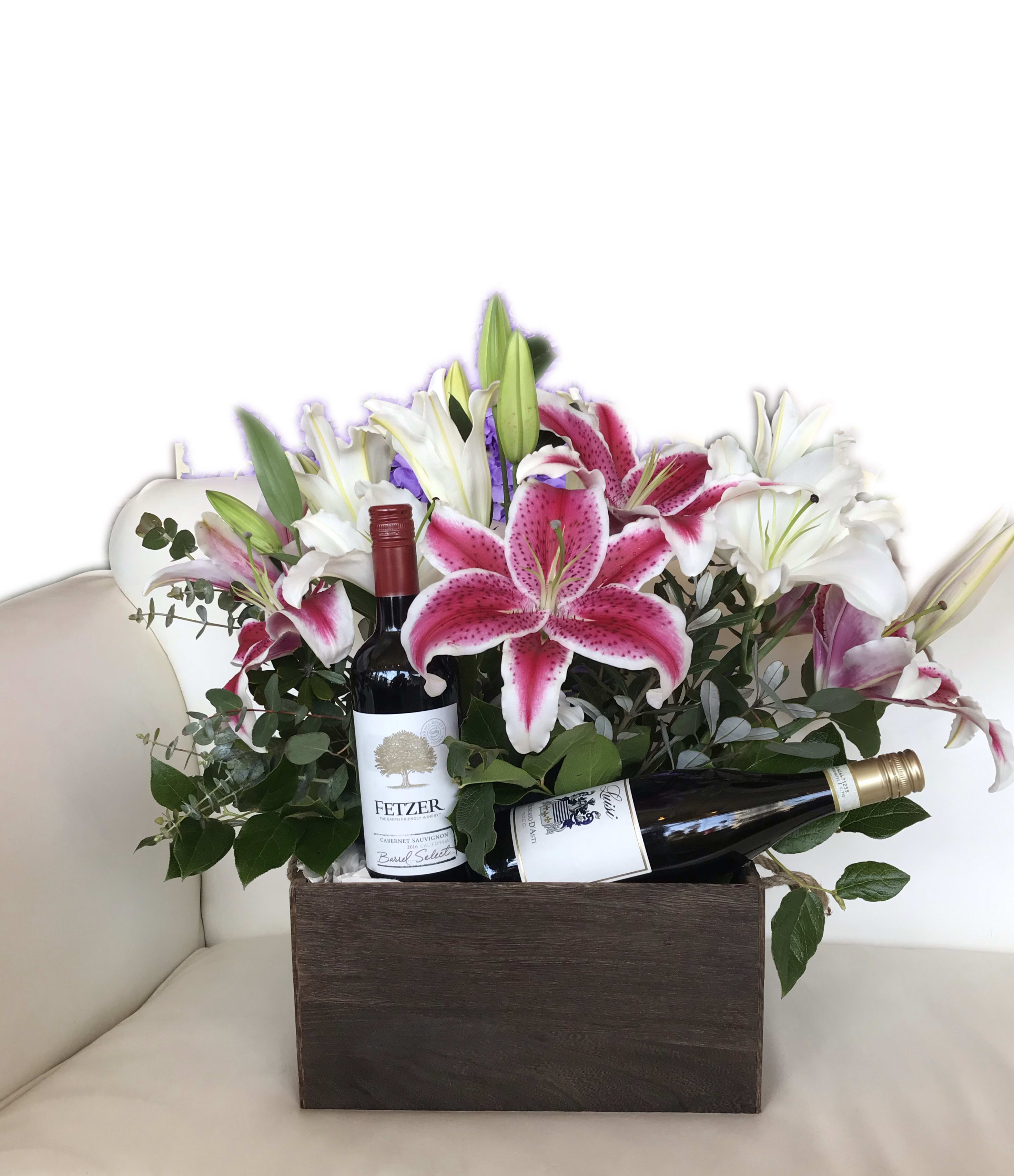 Flower arrangement in a wooden box with two wine bottles